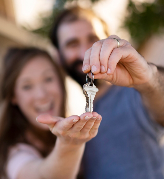Pareja feliz con las llaves de su propiedad recuperada